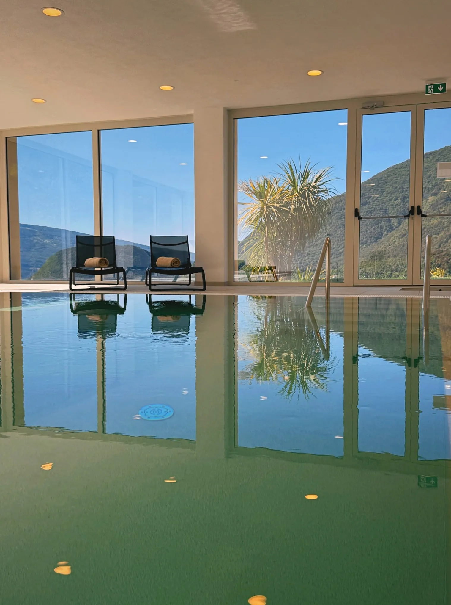 Lounger area by the pool reflected in the water